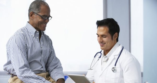 Doctor and patient review medical record on tablet